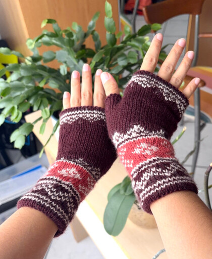 Two hands wearing knitted gloves